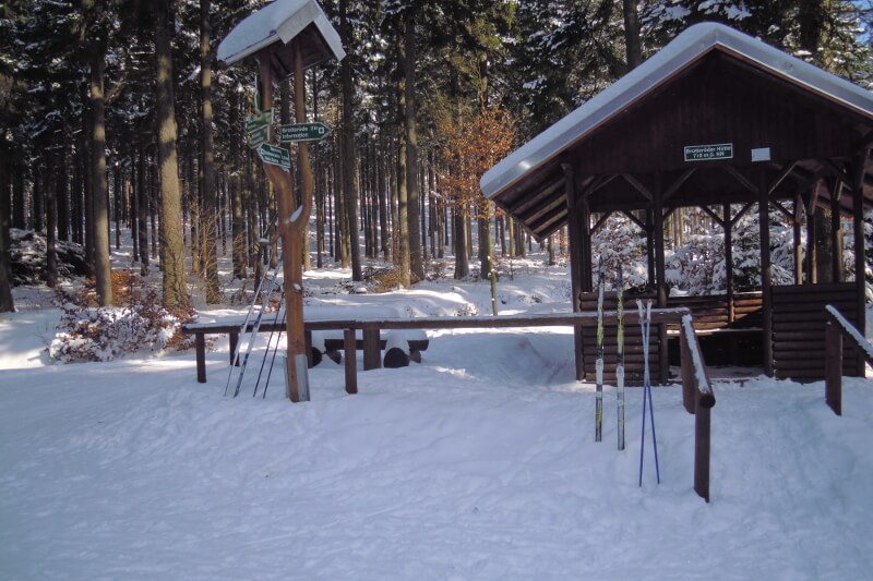 Winter auf dem Rennsteig, Langlaufskier und Wegweiser an Schutzhütte
